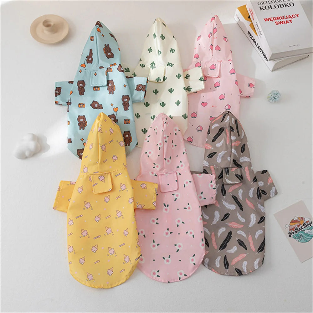 A collection of cartoon printed dog raincoats in various colors and patterns displayed on a white surface.