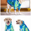 A golden retriever wearing a blue and green tie-dye fleece dog hoodie standing on a floor.