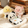 Three soft plush toys of a yellow chick, pink pig, and white panda resting on a cream knitted fabric.