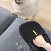 A hand wearing black electrostatic hair removal gloves is removing pet hair from a dog's fur.