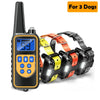A black remote dog training collar with an LCD display is shown next to three orange and yellow dog collars.