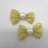 Ein Set aus drei goldenen Glitzer-Schleifenknoten mit Perlen-Mittelpunkt für das Pflegen von Haustieren.