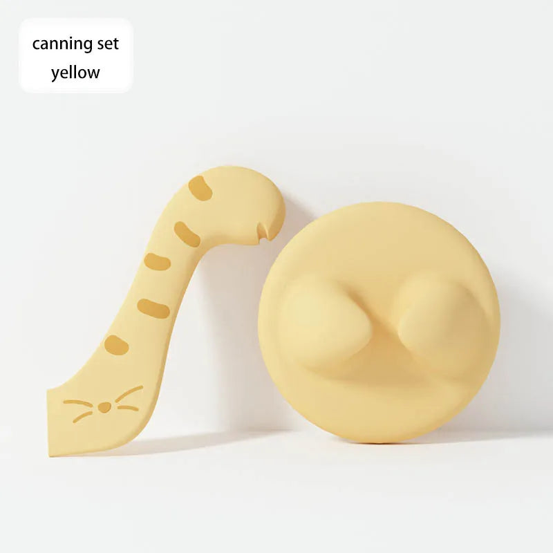 A yellow silicone pet can opener and feeding spoon with a sealing lid.