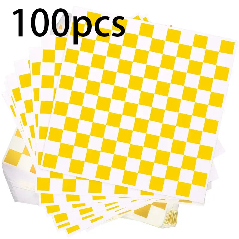 A stack of 100 sheets of yellow and white checkerboard oil-proof sandwich wrapping paper.