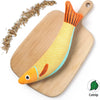 An orange and yellow catnip fish plush toy resting on a wooden cutting board.