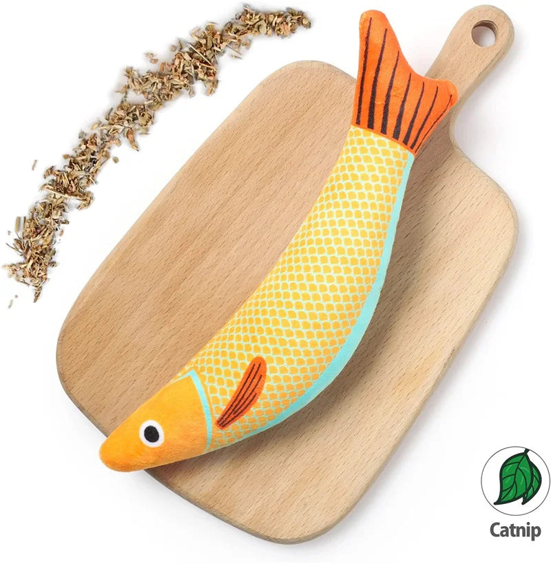 An orange and yellow catnip fish plush toy resting on a wooden cutting board.