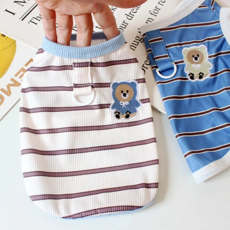 A white striped cooling vest for dogs or cats is shown being held by a hand.