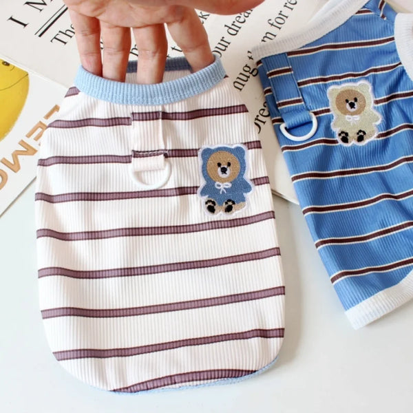 A white striped cooling vest for dogs or cats is shown being held by a hand.