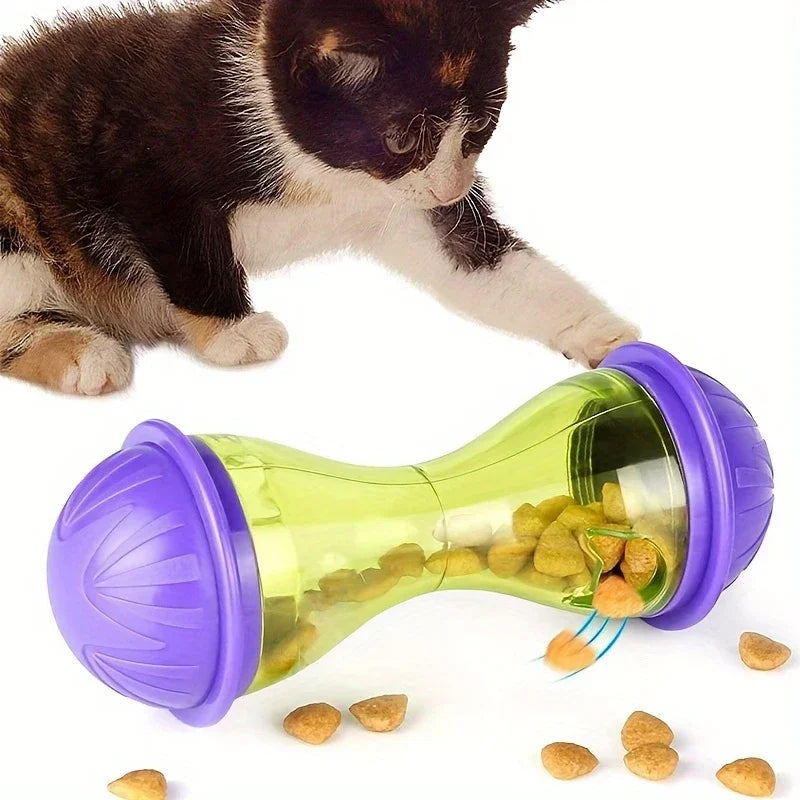 Eine Katze interagiert mit einem lila-grünen Plastikballspielzeug, das als interaktiver Futterspender für Katzen konzipiert i