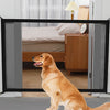 A golden retriever sits in front of a glass door, looking out. The dog is the focus of the image.