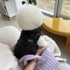 Ein weißer, flauschiger Hund- oder Katzenmantel liegt auf einer weißen Strickoberfläche.