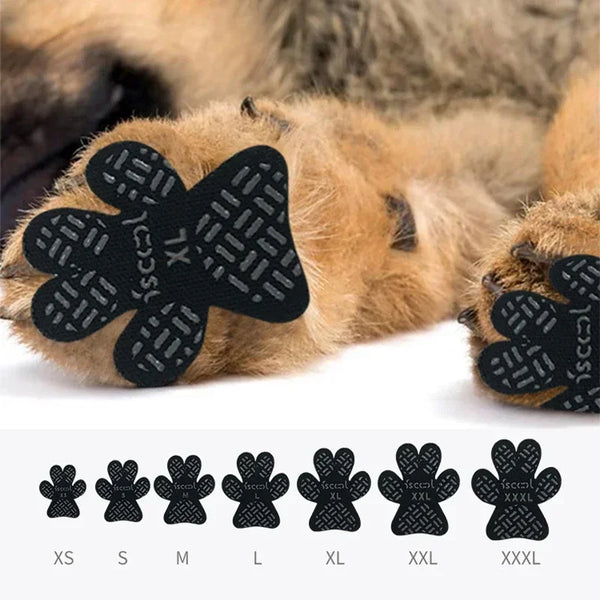 A set of black anti-slip paw protectors for dogs shown on a brown dog's paw.