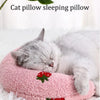 Un chaton gris et duveteux dort paisiblement sur un coussin d'animal rose.
