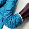A close-up of a bright blue, crinkly drying bag for pets, shown on a purple surface.