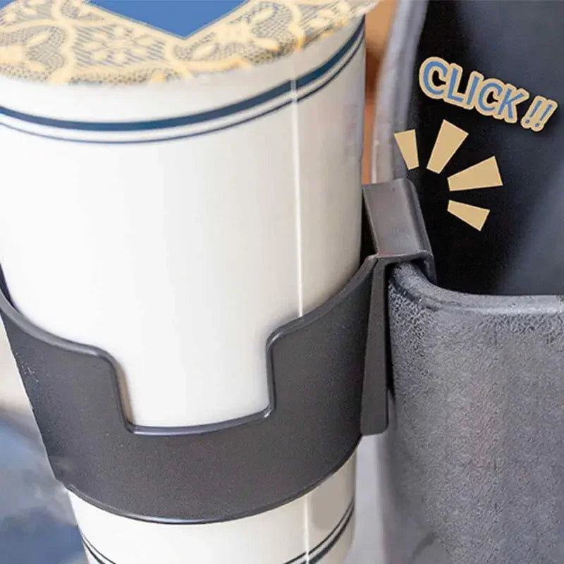 A close-up of a portable vehicle drink holder with a black clamp securing a white cup.