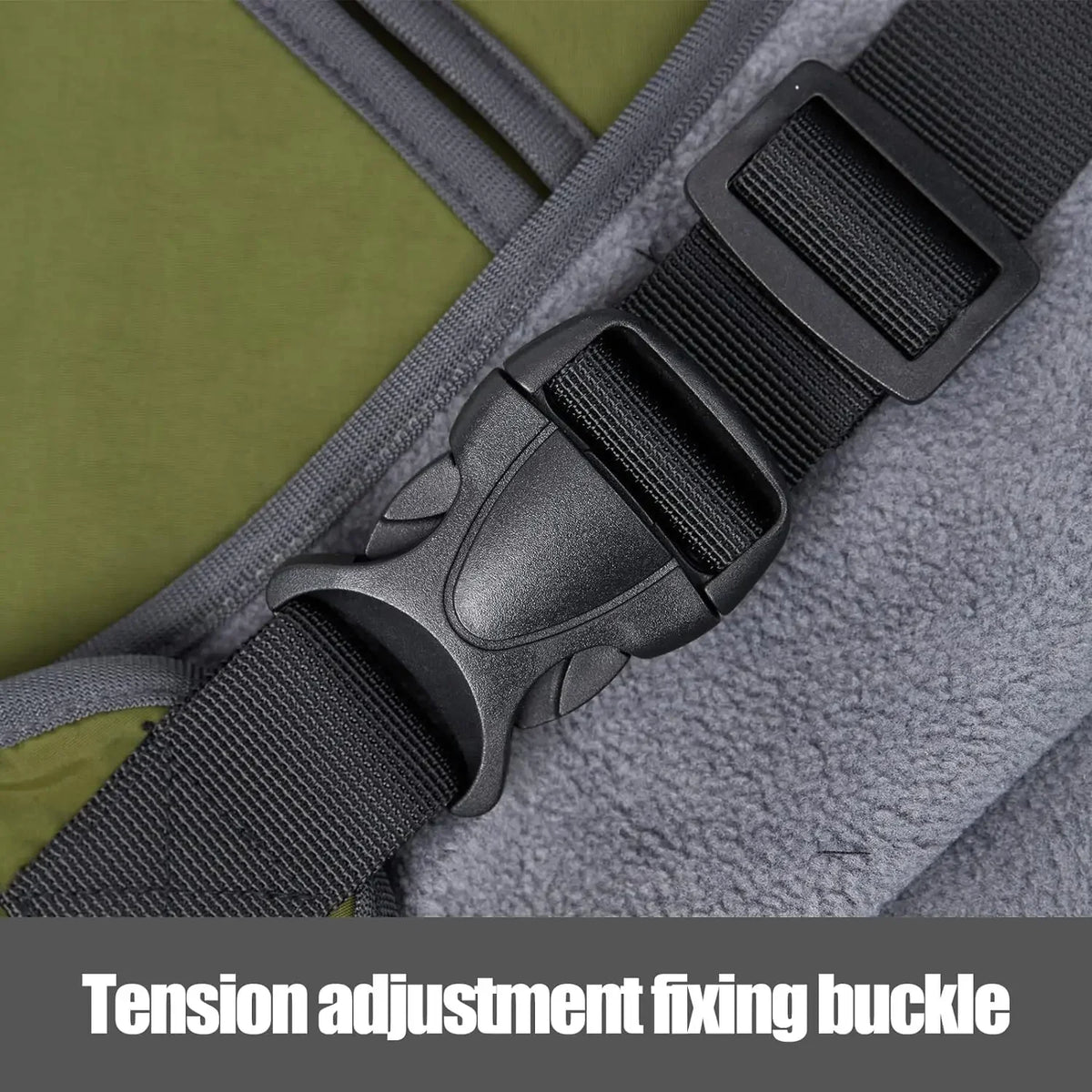 Gros plan sur la boucle de réglage de tension noire sur un harnais gris pour manteau de chien.