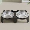 A black stainless steel double pet bowl with an anti-tip design sitting on a light surface.