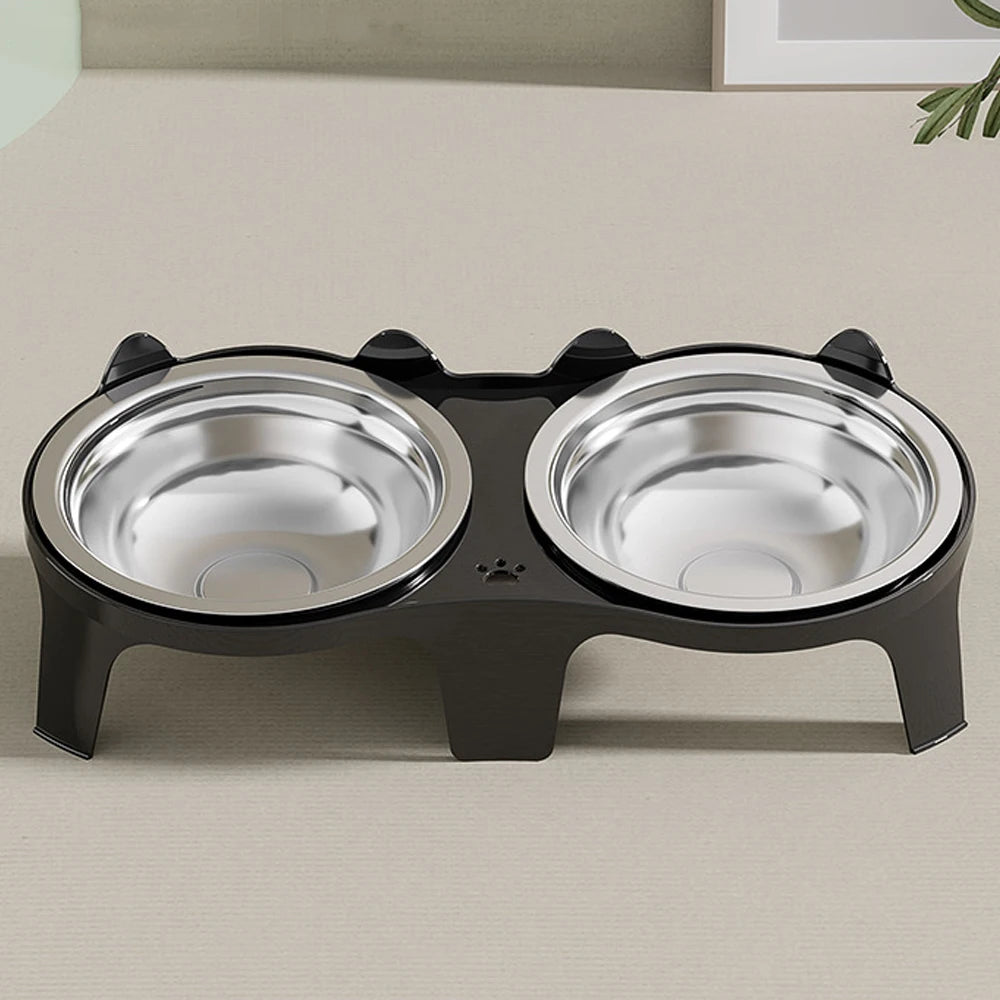 A black stainless steel double pet bowl with an anti-tip design sitting on a light surface.