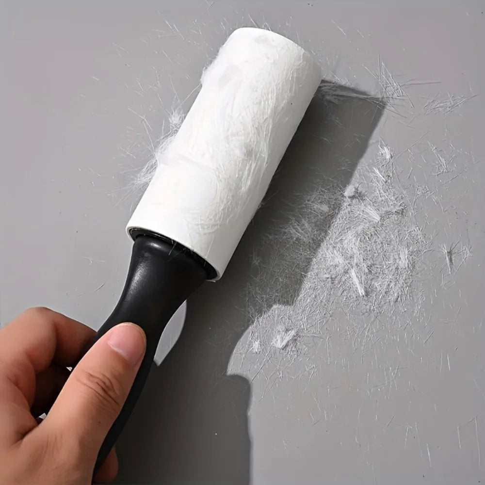 Una mano sostiene un rodillo anti-pelusas blanco reutilizable con mango negro, mostrando su textura y uso contra una superfic