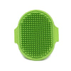 A bright green, oval-shaped soft rubber pet grooming brush with a textured surface.