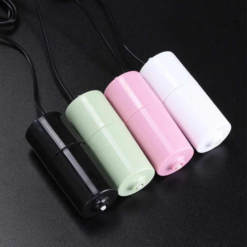 Three portable USB aquarium air pumps in black, light green, and pink are displayed on a dark surface.