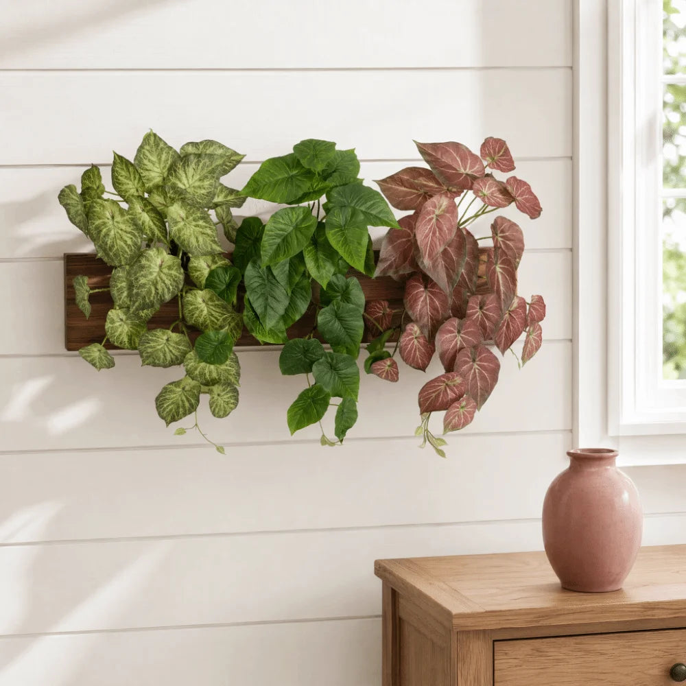 Décor de mur en lierre vert artificiel avec des feuilles vertes et rouge-rosées, exposé sur une étagère en bois.