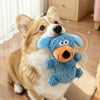 A small dog is holding a blue squeaky plush toy for dogs and cats.