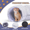 A fluffy white cat tunnel bed with a cat inside, showing features like a hanging ball and non-slip bottom.