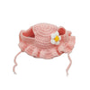 A pink knitted flower hat with a white center bloom and dangling ear loops for pets.