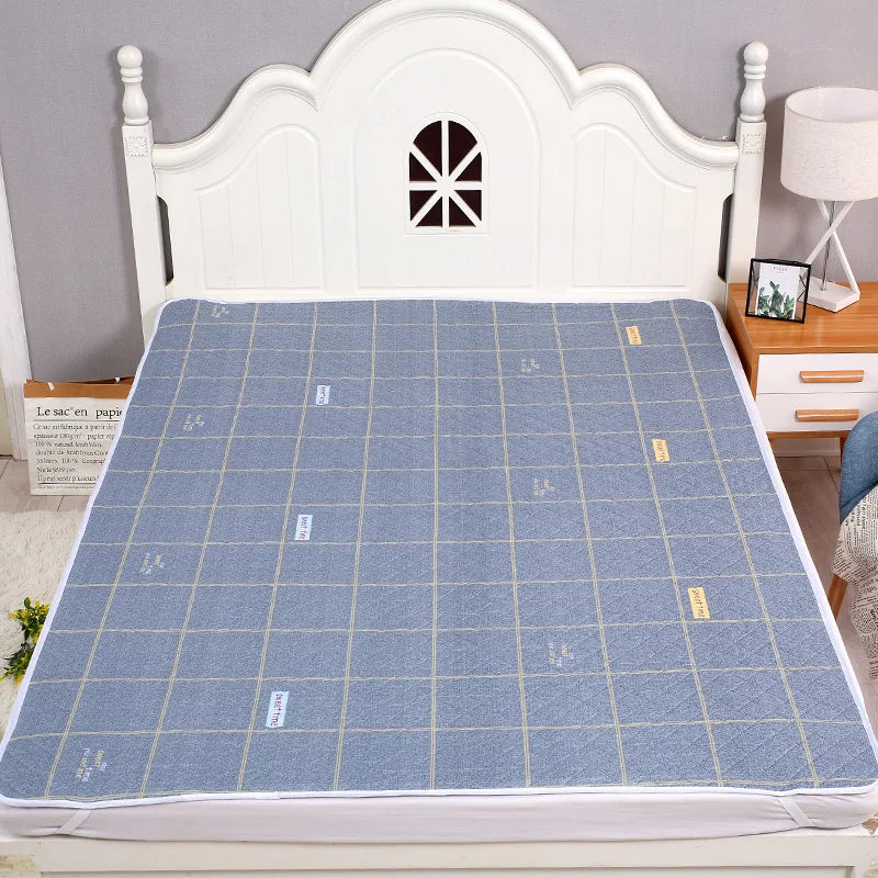 A white wooden headboard with a decorative arch, featuring a blue patterned bed protector pad on a bed.