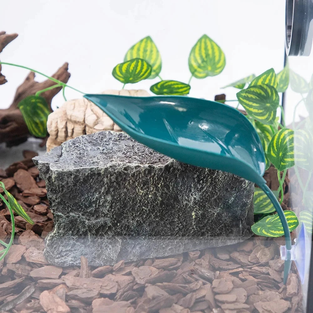 A realistic reptile basking platform made of dark gray rock with a smooth, teal suction cup.