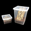 Clear plastic habitat box containing substrate and a rock for a reptile