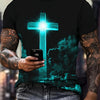 A man wearing a dark t-shirt with a glowing blue cross design and jeans.