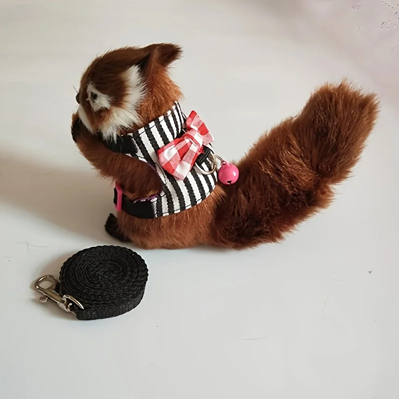 Brauner Hamster mit schwarz-weiß gestreiftem Geschirr und rosa Schleife, an einer schwarzen Leine.