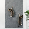 A gray knitted cat scratching mat with two small tabby kittens playing on it.