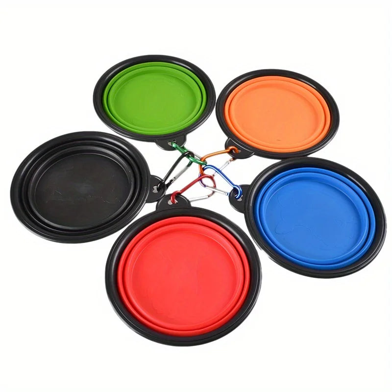 A set of five brightly colored portable silicone dog travel bowls in green, orange, red, and blue.