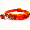 Orange Hamsterrangier mit Glockenverzierung und goldfarbener, glitzernder Riemen.