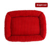 Un lit pour animaux en peluche rouge vif et côtelé, conçu pour chiens et chats.