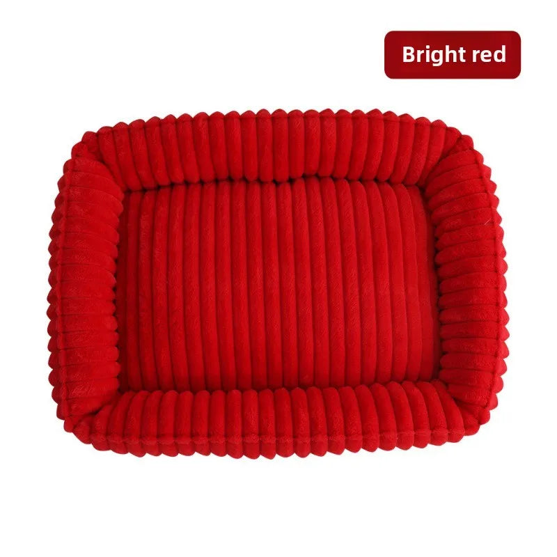 Un lit pour animaux en peluche rouge vif et côtelé, conçu pour chiens et chats.