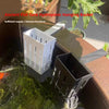 A white hydroponic hanging basket is shown floating in water, used for an ancient fish tank setup.