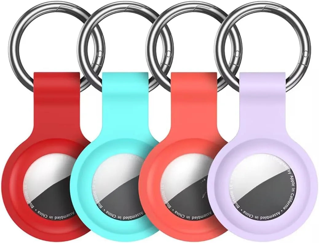 A set of silicone airtag protective covers in red, cyan, and purple attached to metal keychains.