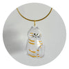 A clear glass charm shaped like a cat with striped markings suspended from a gold-colored cord.