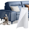 A roll of transparent cat scratch deterrent tape next to a blue sofa with a cat nearby.