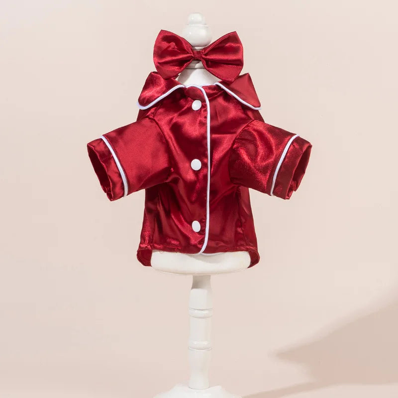 Un conjunto de pijama para perro de satén rojo con una diadema de lazo a juego, mostrado en un maniquí blanco.