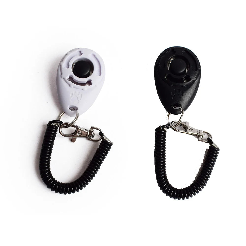 Une paire de clickers d'entraînement pour animaux noirs et blancs avec sangles ajustables à l'en bracelet.