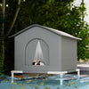 A gray foldable waterproof insulated cat house sitting on a surface with green leaves.