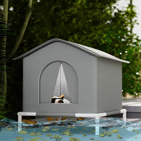 A gray foldable waterproof insulated cat house sitting on a surface with green leaves.