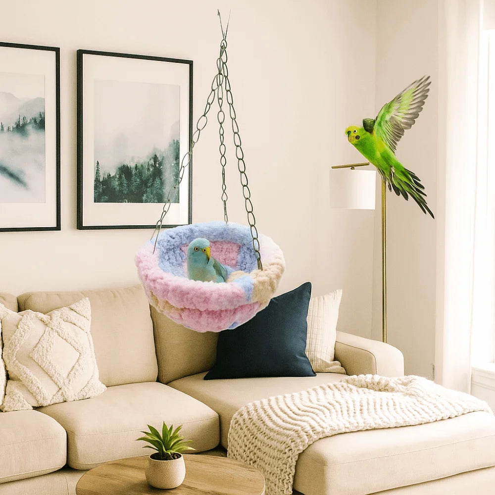 A vibrant green parrot hangs from a chain in an indoor setting above a beige sofa.