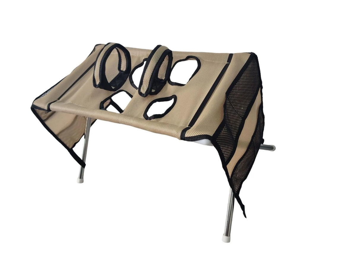 A beige pet grooming hammock with a stand for nail trimming, featuring mesh and fabric sections.