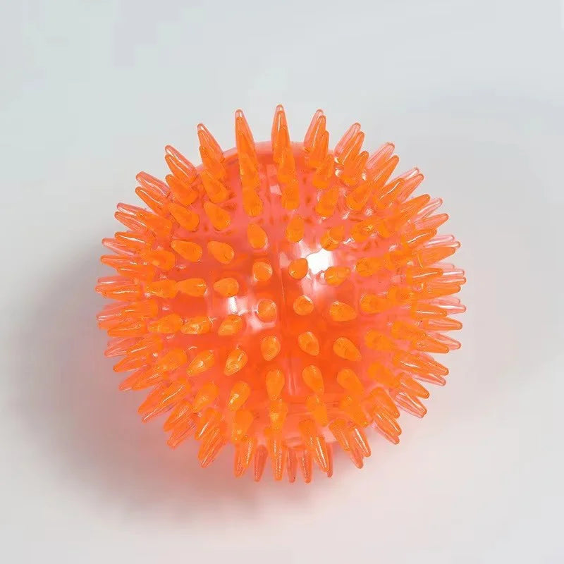 An orange, spiky dog ball designed for teeth cleaning and play.